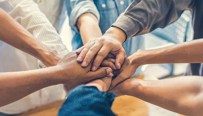 photos avec des mains mêlées représentant une collaboration gagnante
